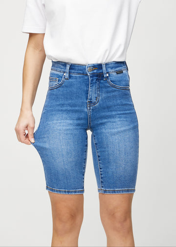 Model strækker shortsene ved låret for at vise stretch.