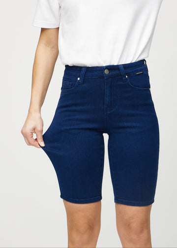 Model strækker shortsene ved låret for at vise stretch.