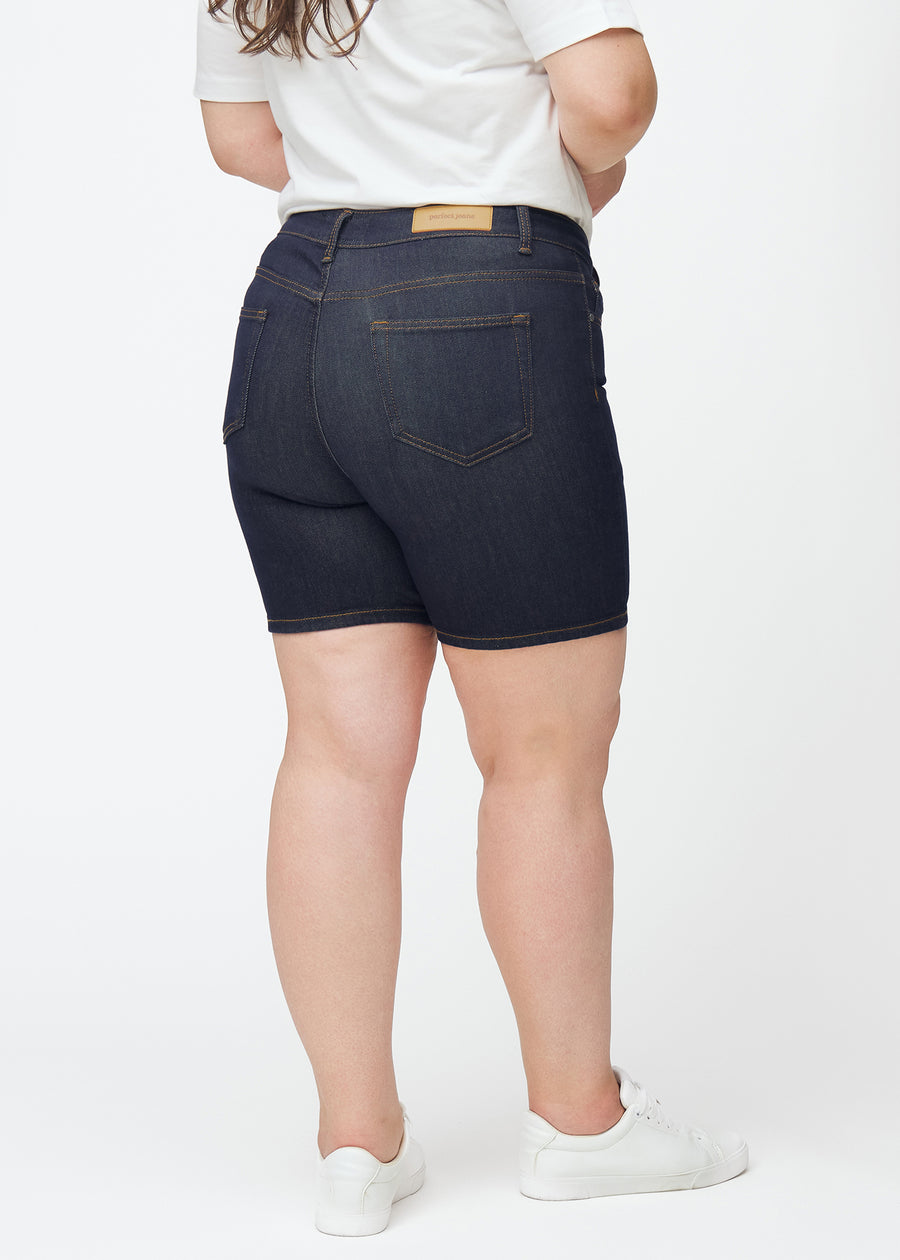 Dyb mørkeblå denim shorts til kvinder i farven Midnights set bagfra på plus-size model, så længden til midt på låret kan ses.