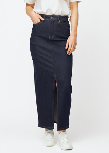 Lang dyb mørkeblå denim nederdel til kvinder i farven Midnights, der sidder til ved hoften og falder lige ned til anklerne, med slids foran der starter lige under knæet, set forfra.