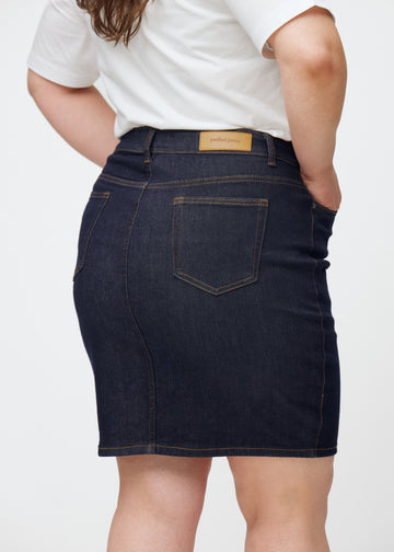 Dyb mørkeblå denim nederdel til kvinder i farven Midnights set bagfra tæt på på plus-size model.