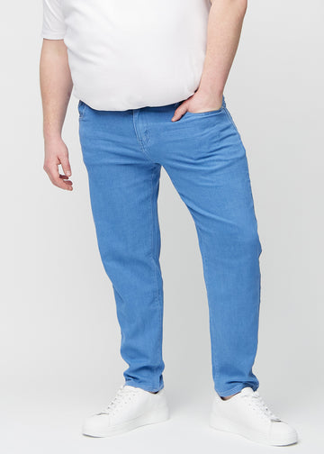 Blå regular jeans, modelnavn Geraniums, som går lige ned langs benet på en plus-size model, set forfra.