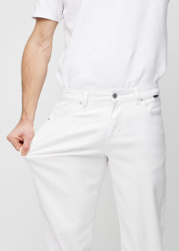 Model strækker jeansene ved låret for at vise stretch.