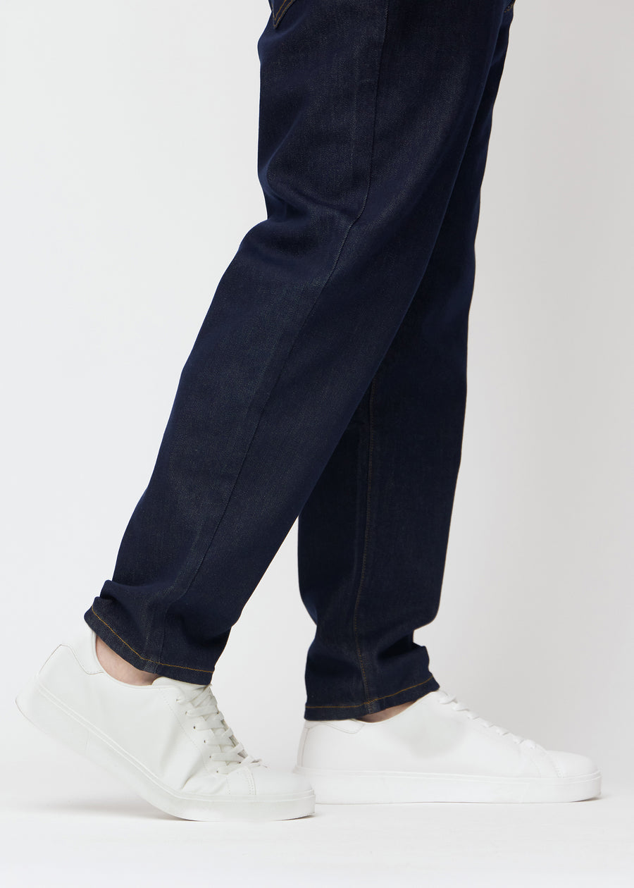Dyb mørkeblå denim jeans til mænd i farven Midnights med regular pasform set tæt på ved anklerne på plus-size model for at vise den lige afslutning.
