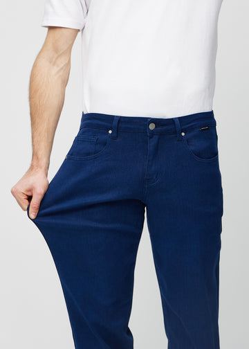 Model strækker jeansene ved låret for at vise stretch.