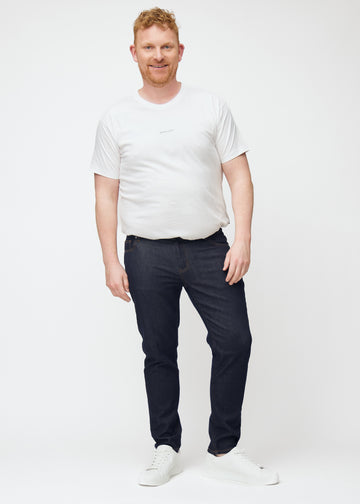 Fuldt billede af plus-size model i dyb mørkeblå denim jeans til mænd i farven Midnights med slim pasform.
