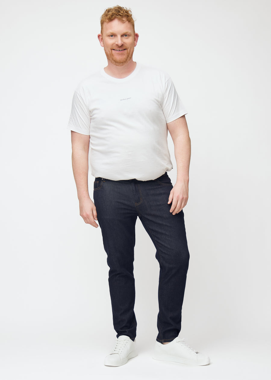Fuldt billede af plus-size model i dyb mørkeblå denim jeans til mænd i farven Midnights med slim pasform.
