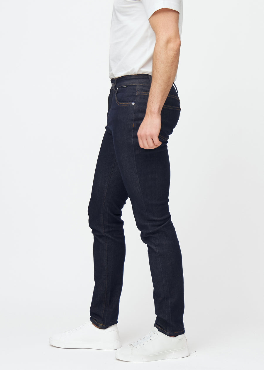 Dyb mørkeblå denim jeans til mænd i farven Midnights med slim pasform set fra siden på model.