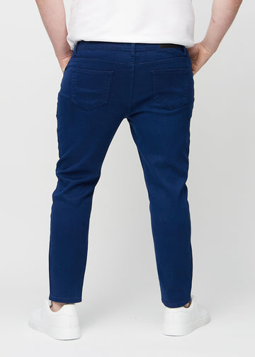 Mørkeblå slim jeans set bagfra på en plus-size model, så man kan se hele produktet.