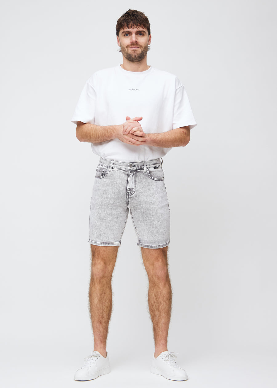 Fuldt billede af model i lysegrå denim middle-slim shorts.