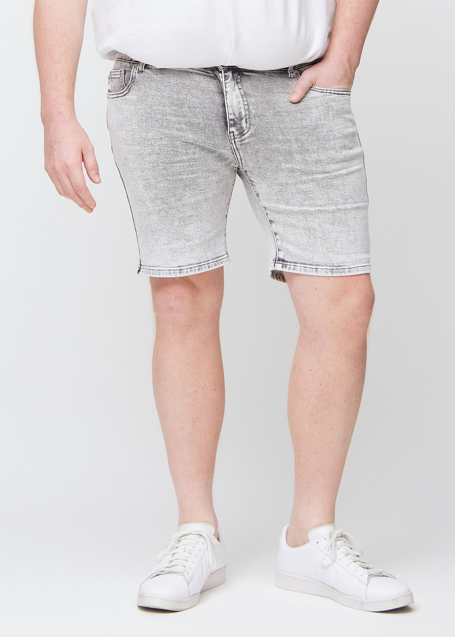 Lysegrå denim middle-slim shorts, som sidder lige langs låret og slutter lige over knæet på en plus-size model, set forfra.