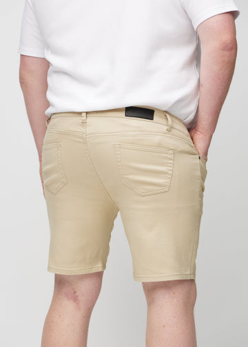 Beige middle-slim shorts set bagfra tæt på en plus-size model for at vise detaljer.
