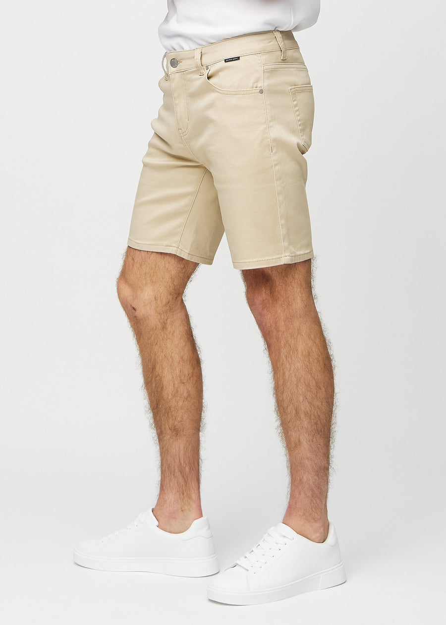 Beige middle-slim shorts set fra siden på model.