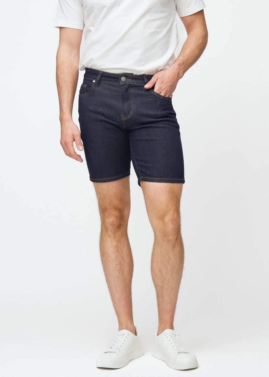 Dyb mørkeblå denim shorts til mænd i farven Midnights med slim pasform, der sidder naturligt ved hoften og følger lårene tættere end regular, set forfra.