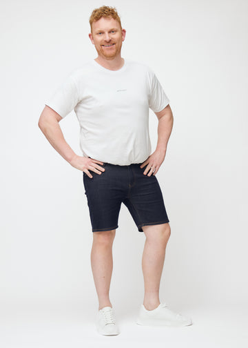 Fuldt billede af plus-size model i dyb mørkeblå denim shorts til mænd i farven Midnights med slim pasform.