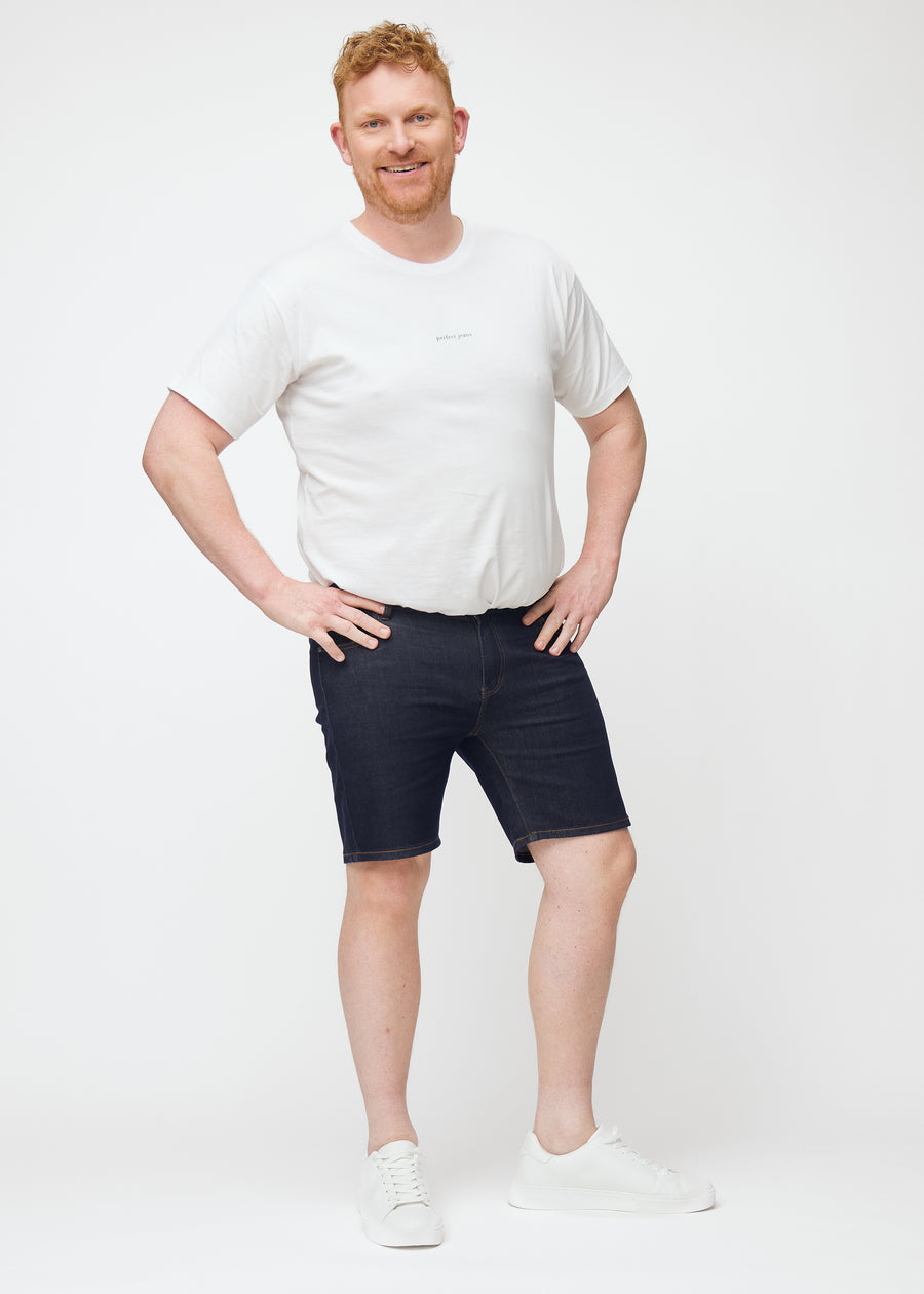 Fuldt billede af plus-size model i dyb mørkeblå denim shorts til mænd i farven Midnights med slim pasform.
