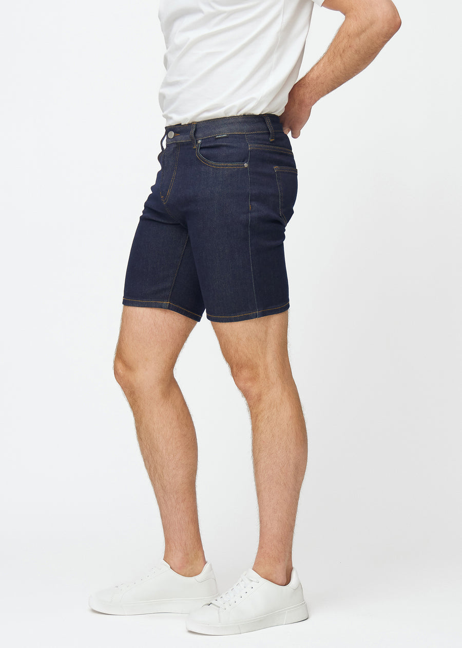 Dyb mørkeblå denim shorts til mænd i farven Midnights med slim pasform set fra siden på model.