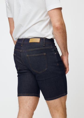 Dyb mørkeblå denim shorts til mænd i farven Midnights set bagfra tæt på for at vise pasform og detaljer.