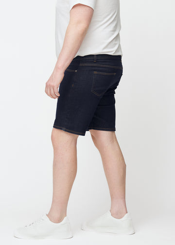 Dyb mørkeblå denim shorts til mænd i farven Midnights med slim pasform set fra siden på plus-size model.