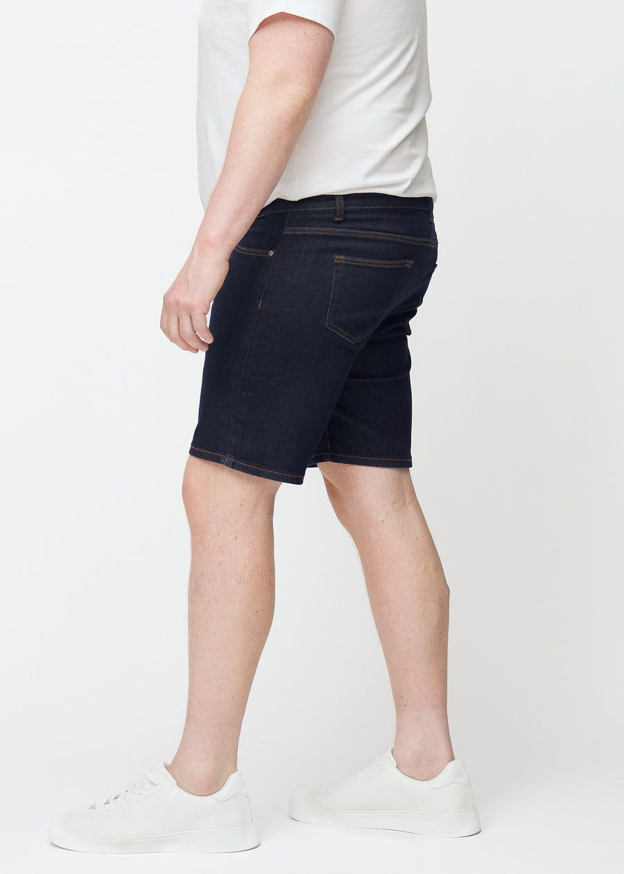 Dyb mørkeblå denim shorts til mænd i farven Midnights med slim pasform set fra siden på plus-size model.