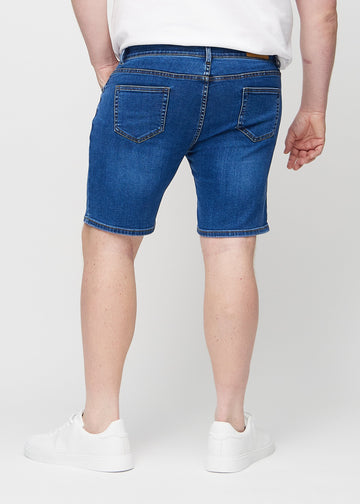 Mørk denim middle-slim shorts set bagfra på en plus-size model, så man kan se hele produktet.