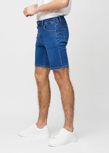 Mørk denim middle-slim shorts set fra siden på model.