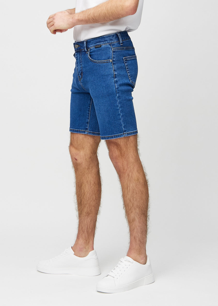 Mørk denim middle-slim shorts set fra siden på model.