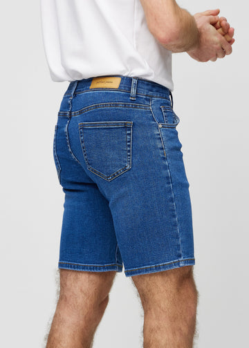Mørk denim middle-slim shorts set bagfra tæt på for at vise detaljer.