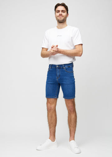 Fuldt billede af model i mørk denim middle-slim shorts.