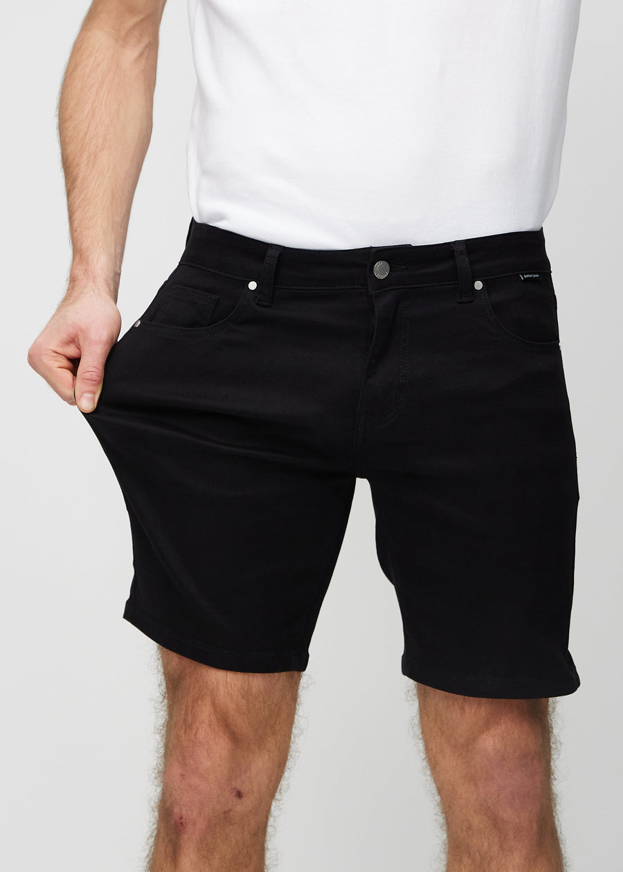 Model strækker shortsene ved låret for at vise stretch.