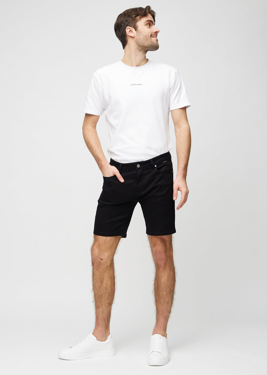 Fuldt billede af model i sorte middle-slim shorts.