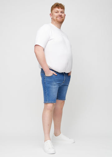 Fuldt billede af en plus-size model i denim middle-slim shorts.