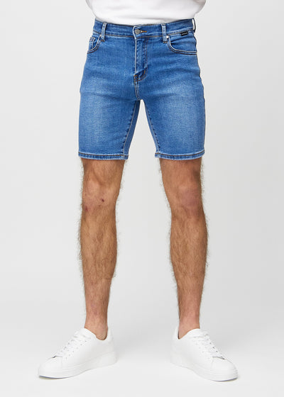 Denim middle-slim shorts, som sidder lige langs låret og slutter lige over knæet, set forfra.