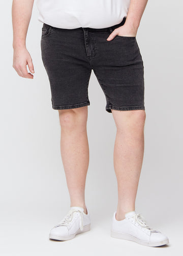 Mørkegrå denim middle-slim shorts, som sidder lige langs låret og slutter lige over knæet på en plus-size model, set forfra.