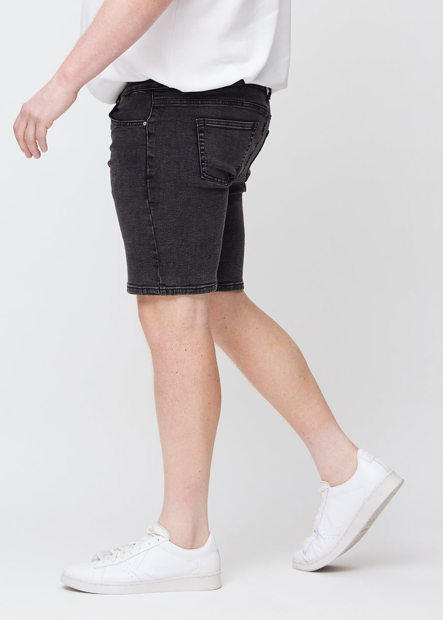 Mørkegrå denim middle-slim shorts set fra siden på en plus-size model.