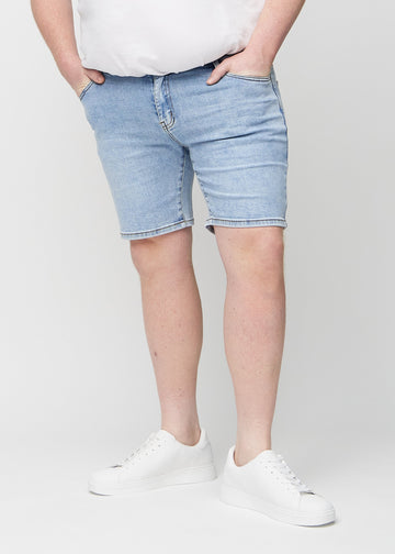 Lys denim middle-slim shorts, som sidder lige langs låret og slutter lige over knæet på en plus-size model, set forfra.
