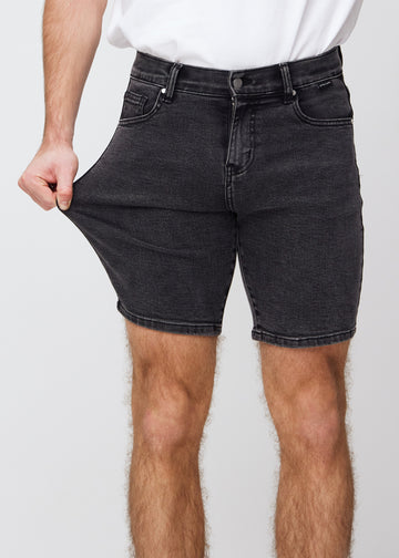 Model strækker shortsene ved låret for at vise stretch.