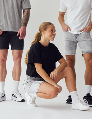 Kvinder og mænd iført shorts fra Perfect Jeans i en lysegrå og mørkegrå denim farve.