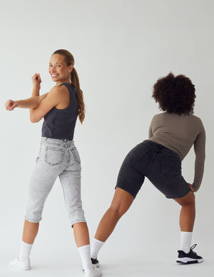To kvinder i korte grå denim shorts og capris, der strækker ud, for a t vise hvor strækbare de er.