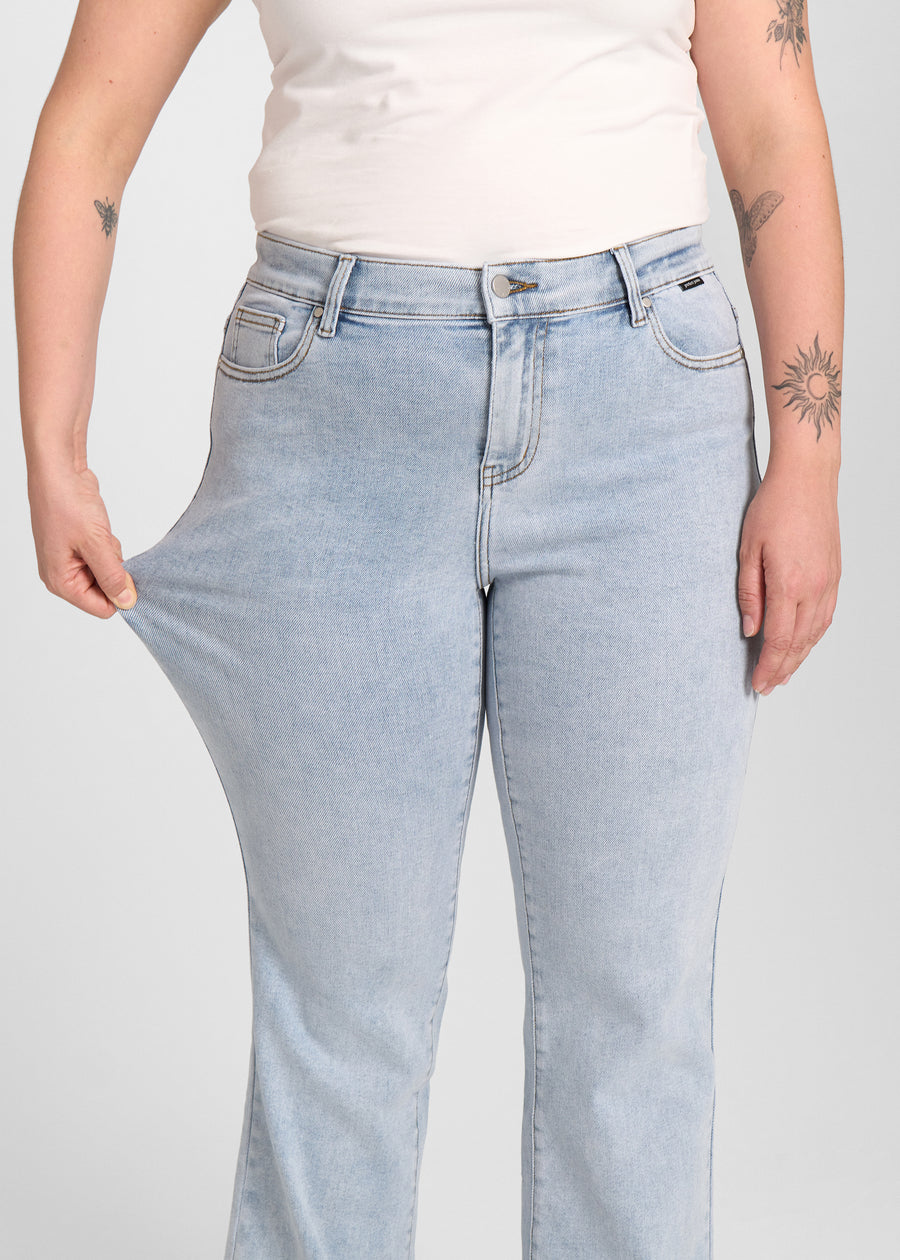 Model strækker jeansene ved låret for at vise stretch.