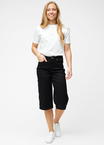 Model viser løse, sorte capris i farven Ravens i bevægelse og demonstrerer pasform og materiale.