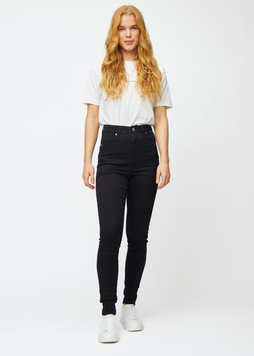 En model i sorte high rise skinny jeans til kvinder i farven Ravens vises i bevægelse.